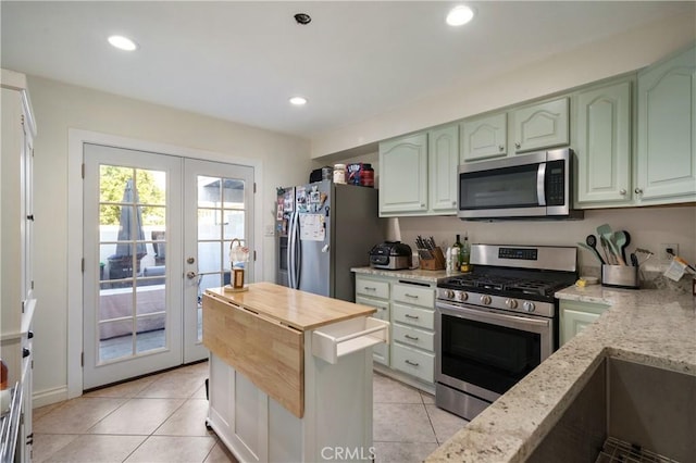 kitchen with appliances with stainless steel finishes, light stone counters, french doors, green cabinets, and recessed lighting