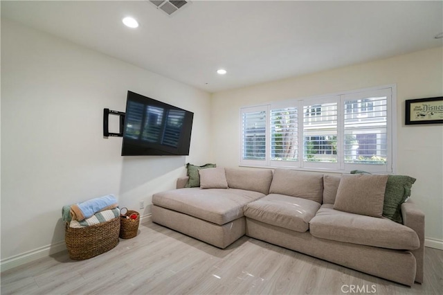 living room featuring baseboards, visible vents, wood finished floors, and recessed lighting