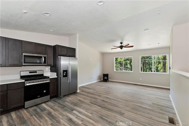 kitchen with visible vents, appliances with stainless steel finishes, wood finished floors, vaulted ceiling, and light countertops