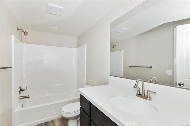 full bath with visible vents, toilet, wood finished floors,  shower combination, and vanity