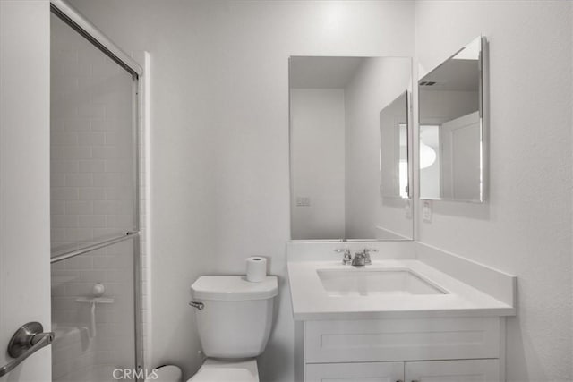 full bathroom featuring a shower with door, vanity, and toilet