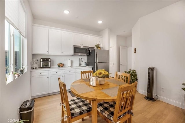 dining area with light wood-style floors, recessed lighting, a toaster, and baseboards