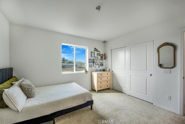 bedroom with a closet and light colored carpet