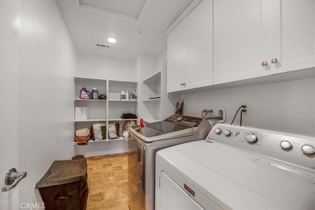 laundry area featuring visible vents, washer and clothes dryer, and cabinet space