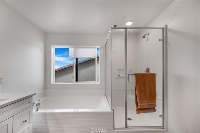 full bathroom featuring a shower stall, vanity, and a bath