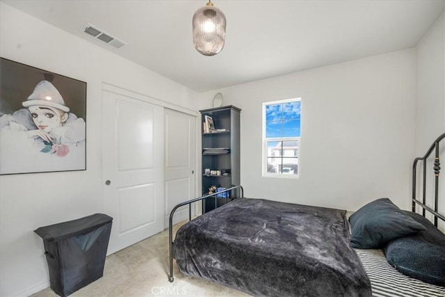 bedroom with visible vents, a closet, and light colored carpet