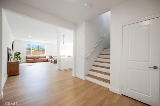 stairs with recessed lighting, wood finished floors, and baseboards