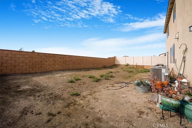 view of yard featuring a fenced backyard and central AC