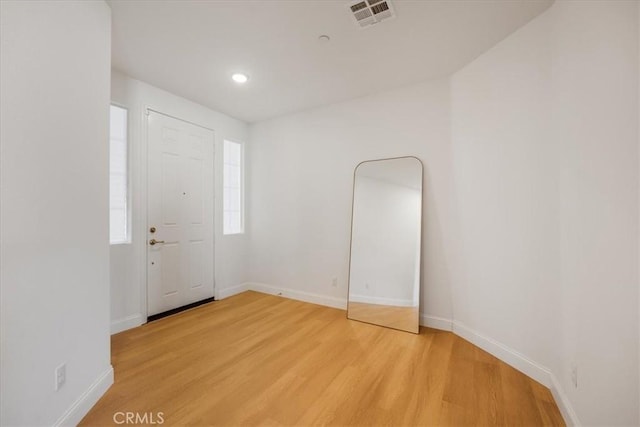 entryway featuring light wood-type flooring, baseboards, visible vents, and recessed lighting