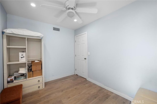 interior space featuring visible vents, ceiling fan, baseboards, and wood finished floors