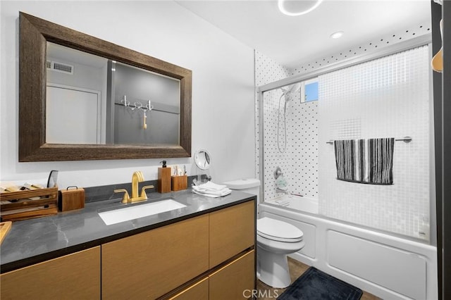 bathroom with visible vents, shower / bath combination with glass door, vanity, and toilet