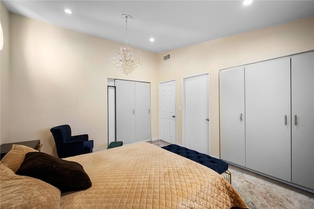 bedroom featuring a chandelier, recessed lighting, visible vents, and two closets