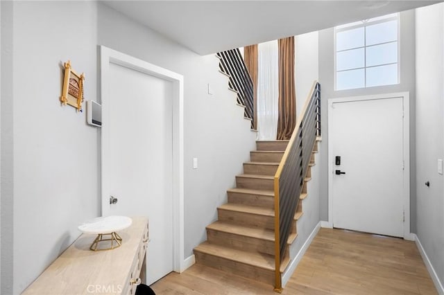 staircase featuring baseboards and wood finished floors