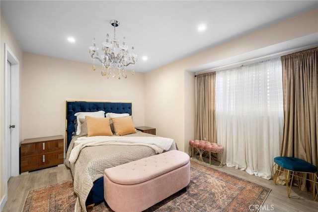 bedroom featuring recessed lighting, wood finished floors, and an inviting chandelier