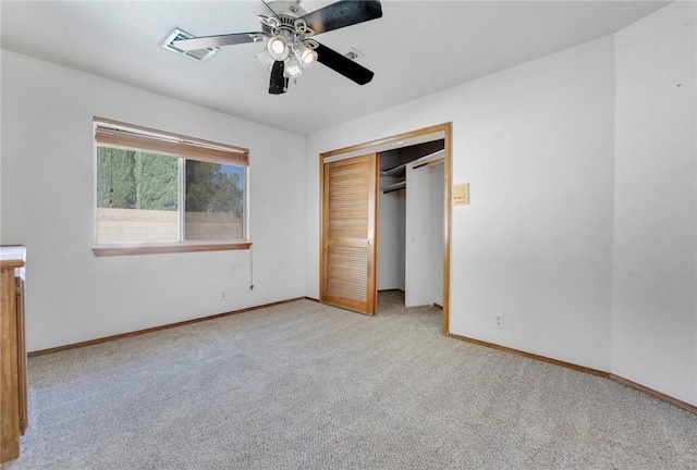 unfurnished bedroom with ceiling fan, light colored carpet, visible vents, baseboards, and a closet