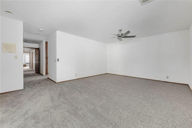 unfurnished room featuring a ceiling fan, light colored carpet, and baseboards