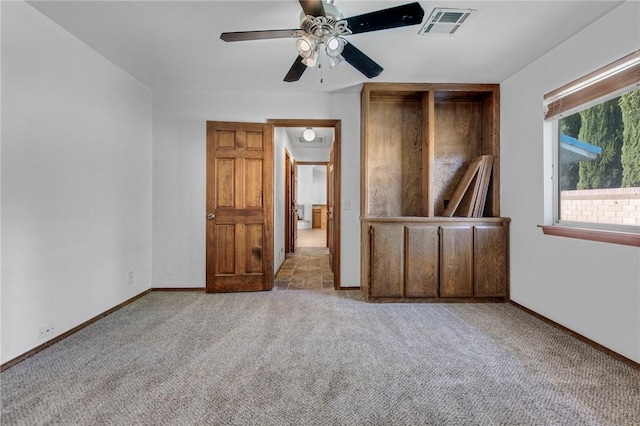 unfurnished bedroom with ceiling fan, carpet floors, visible vents, and baseboards