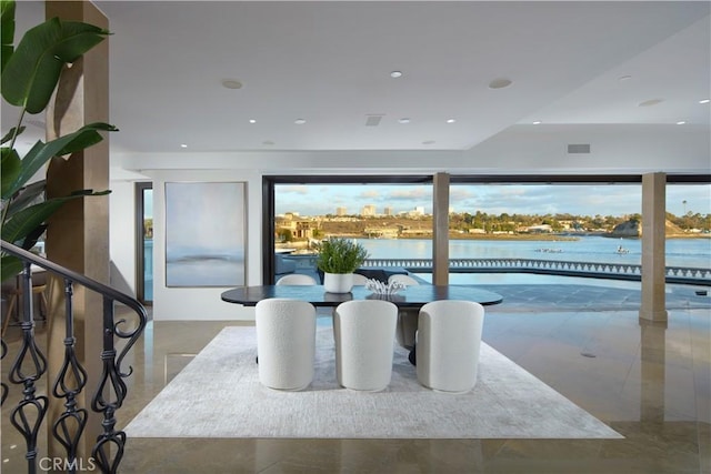 dining area with a water view, visible vents, and recessed lighting