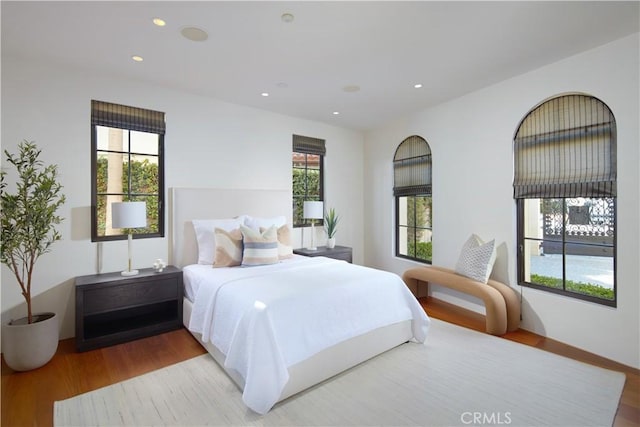 bedroom with recessed lighting, multiple windows, and wood finished floors