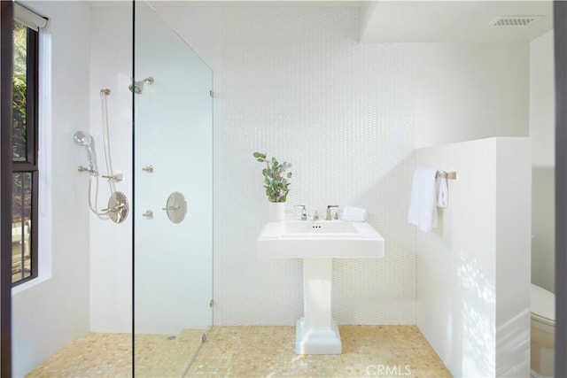 full bathroom with toilet, tile walls, walk in shower, and visible vents