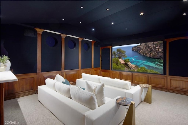carpeted home theater featuring lofted ceiling and a decorative wall