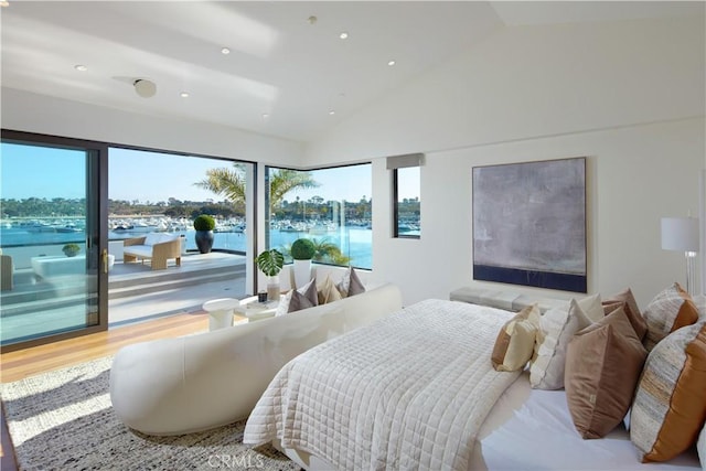 bedroom with access to outside, wood finished floors, vaulted ceiling, and recessed lighting