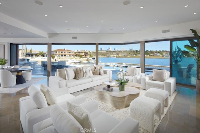 living room with a water view, visible vents, recessed lighting, and plenty of natural light
