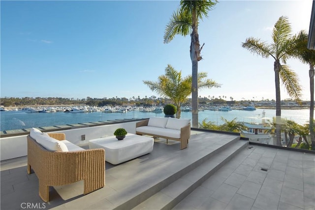 view of patio featuring outdoor lounge area, a water view, and a balcony
