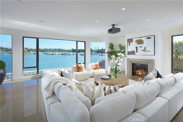 living room featuring a high end fireplace, a water view, and recessed lighting