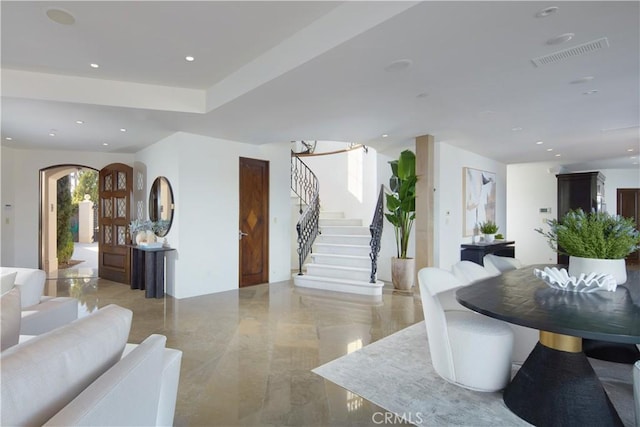 interior space with stairway, recessed lighting, marble finish floor, arched walkways, and visible vents