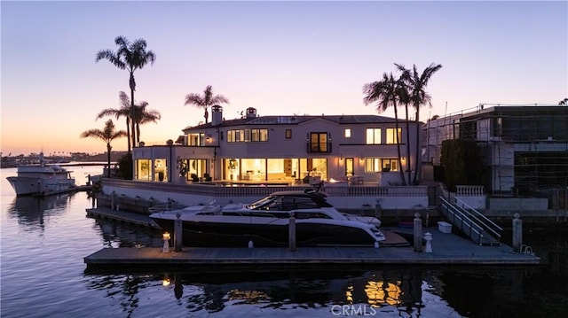 rear view of property featuring a water view and stucco siding