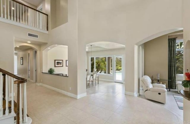 entryway featuring arched walkways, visible vents, and baseboards