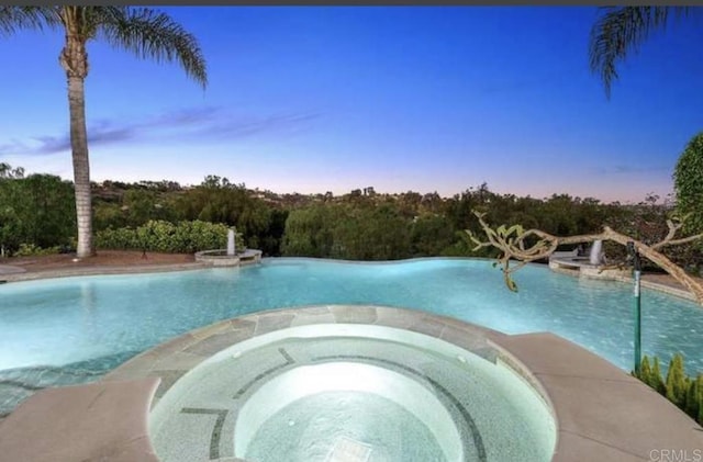 view of swimming pool with a pool with connected hot tub