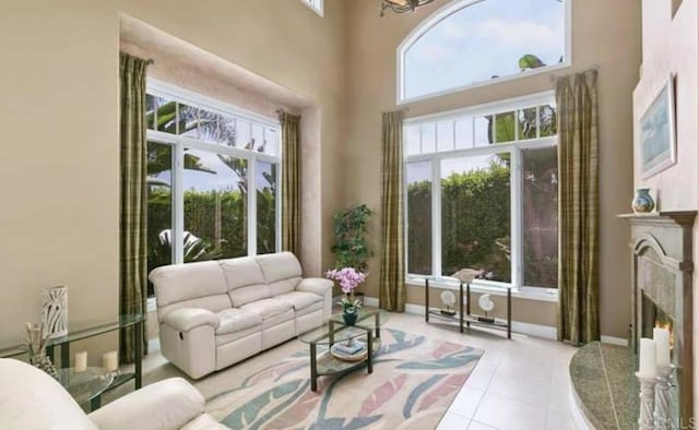 interior space with a high ceiling, a premium fireplace, a wealth of natural light, and baseboards