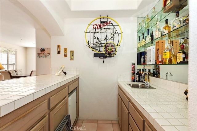 bar featuring light tile patterned floors, indoor wet bar, and a sink