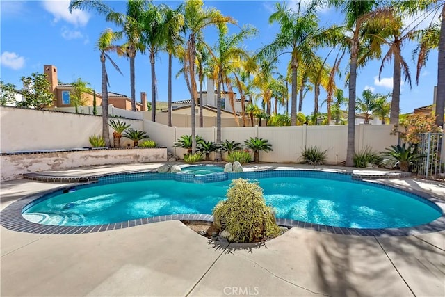 view of pool with a patio area, a pool with connected hot tub, and a fenced backyard