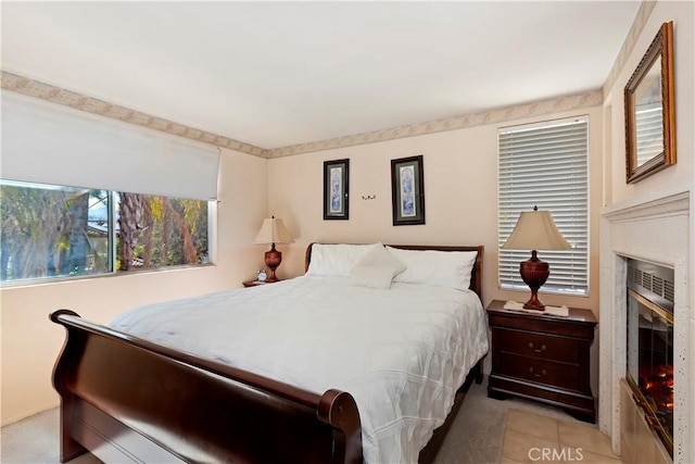 bedroom featuring a glass covered fireplace