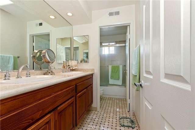 full bath featuring bath / shower combo with glass door, a sink, and visible vents