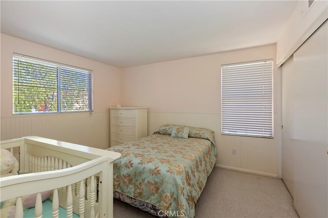 bedroom featuring a wainscoted wall and carpet floors