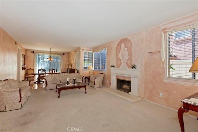 living area featuring carpet floors, plenty of natural light, and a glass covered fireplace