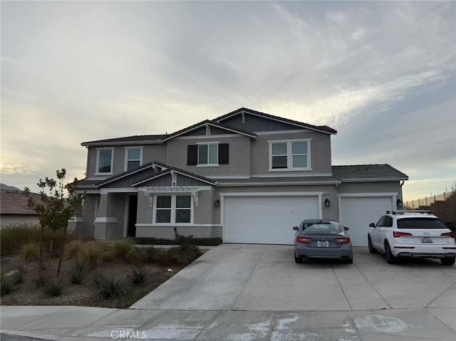 view of front of property with a garage, concrete driveway, and stucco siding