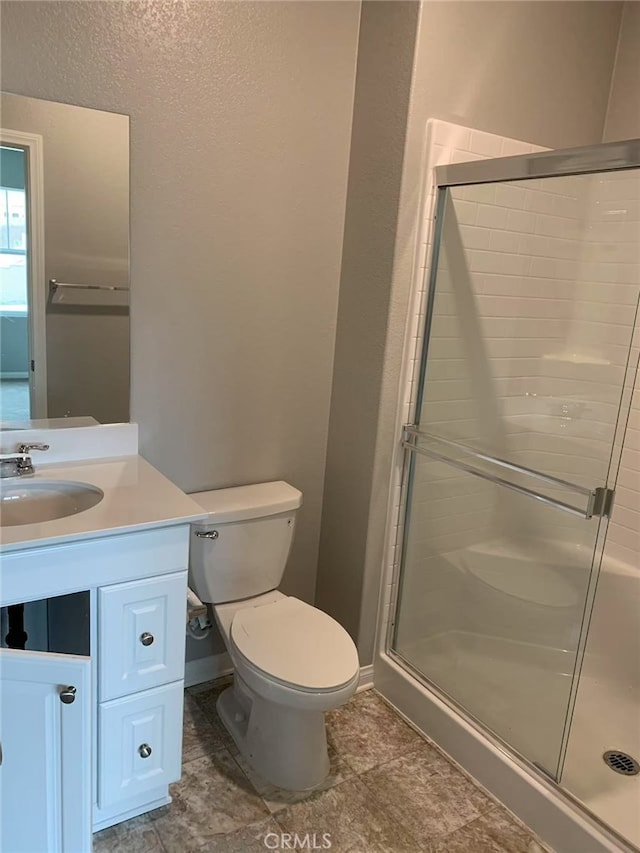 full bathroom featuring toilet, a shower stall, and vanity