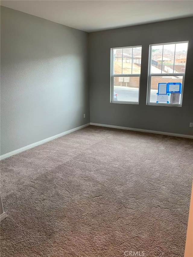 carpeted empty room with baseboards