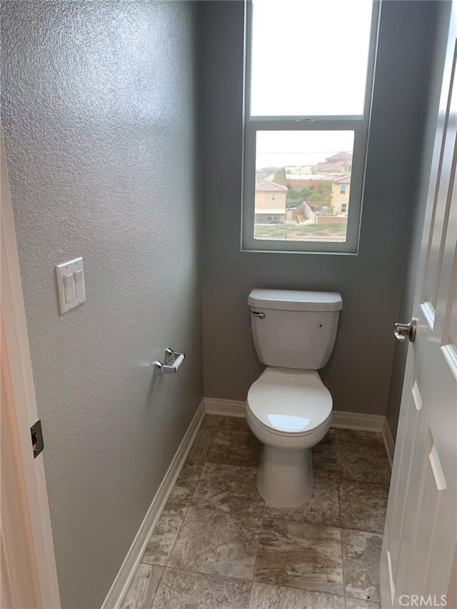 bathroom with toilet and baseboards