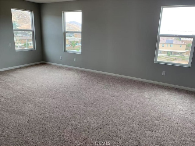 empty room with carpet and baseboards