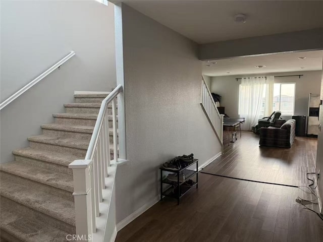 staircase with wood finished floors and baseboards