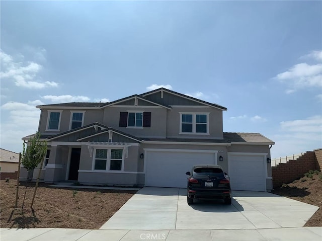 craftsman house with a garage, driveway, and stucco siding