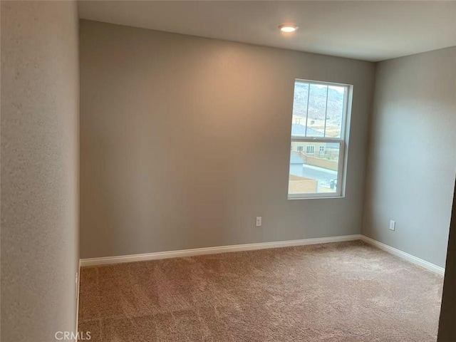 carpeted spare room with baseboards