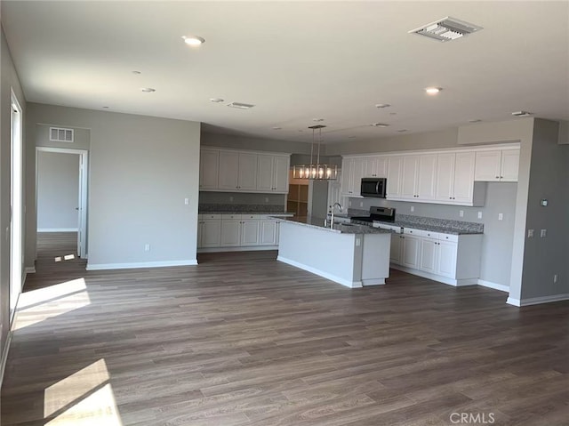 kitchen with black microwave, white cabinetry, visible vents, and stainless steel electric stove