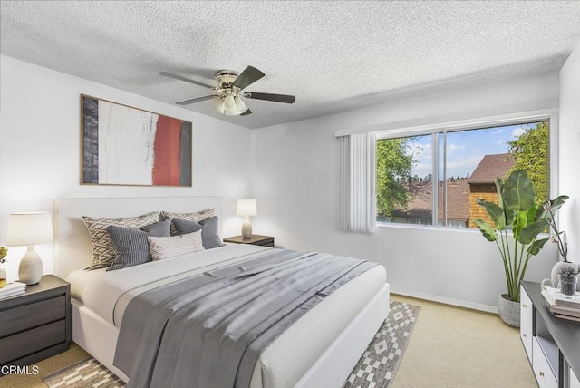 bedroom featuring baseboards, a textured ceiling, a ceiling fan, and carpet flooring